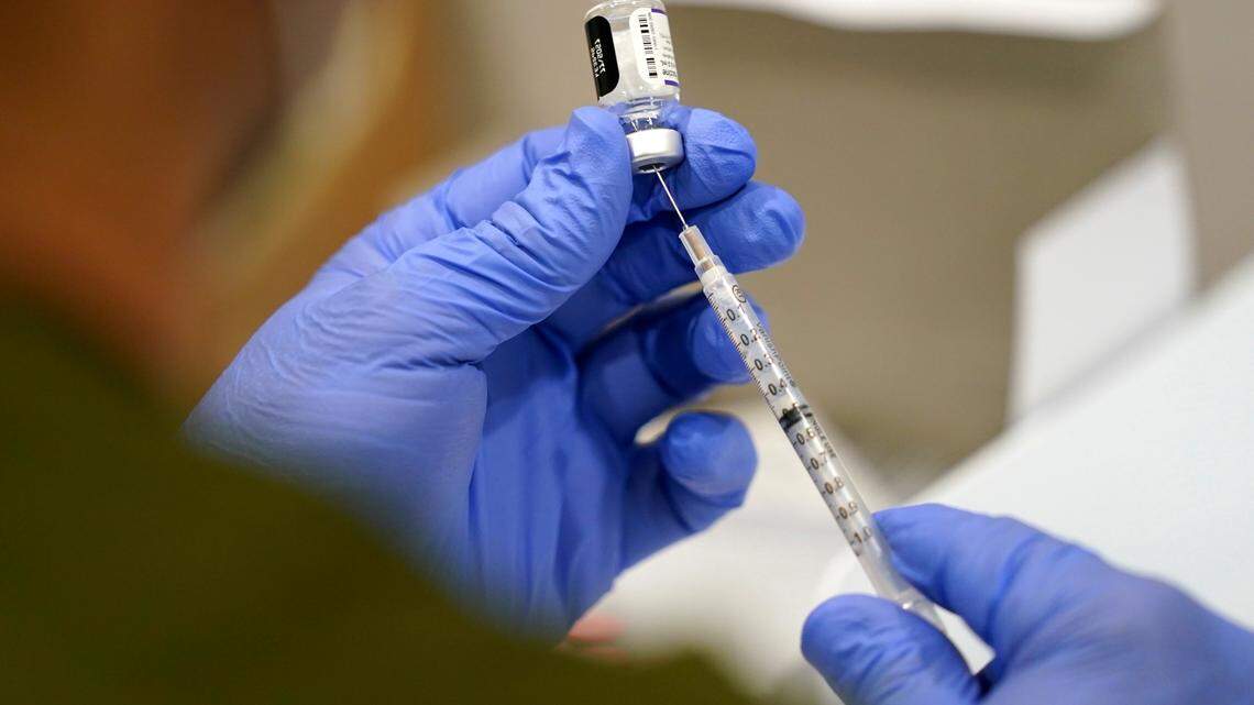 A healthcare worker fills a syringe with the Pfizer COVID-19 vaccine at Jackson Memorial Hospital in Miami.