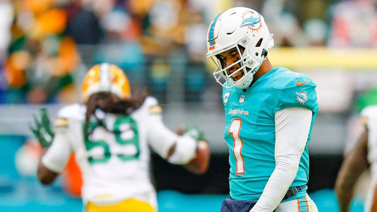 Miami Dolphins quarterback Tua Tagovailoa (1) walks off the field as Green Bay Packers linebacker De’Vondre Campbell (59) celebrates after an interception in the fourth quarter Hard Rock Stadium in Miami Gardens, Florida on Sunday, December 25, 2022.