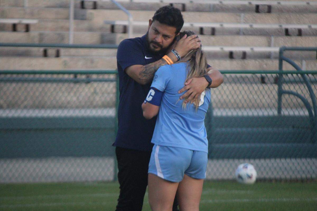Lourdes girls’ soccer coach David Fique consoles a distraught senior Coco Aguilar following a 4-1 loss to Gulf Breeze Friday afternoon in the Class 6A state girls’ soccer championship match in DeLand.