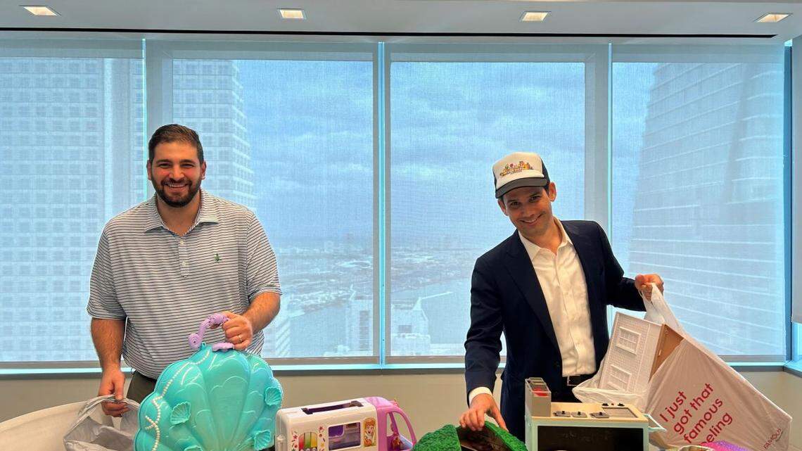 Greenberg Traurig attorneys Sami Ghneim and Win Rutherfurd prepare toy kits for kids to borrow at the public library through the Play It Forward South Florida Toy Library.
