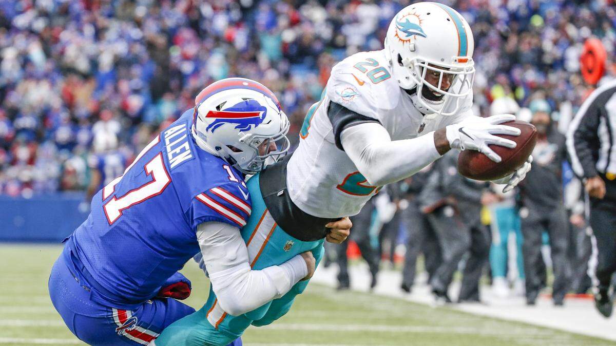 Miami Dolphins free safety Reshad Jones (20) scores late in the second quarter as Buffalo Bills quarterback Josh Allen (17) attempts the stop as the Buffalo Bills host the Miami Dolphins at New Era Field, Orchard Park, NY on Sunday, December 30, 2018.