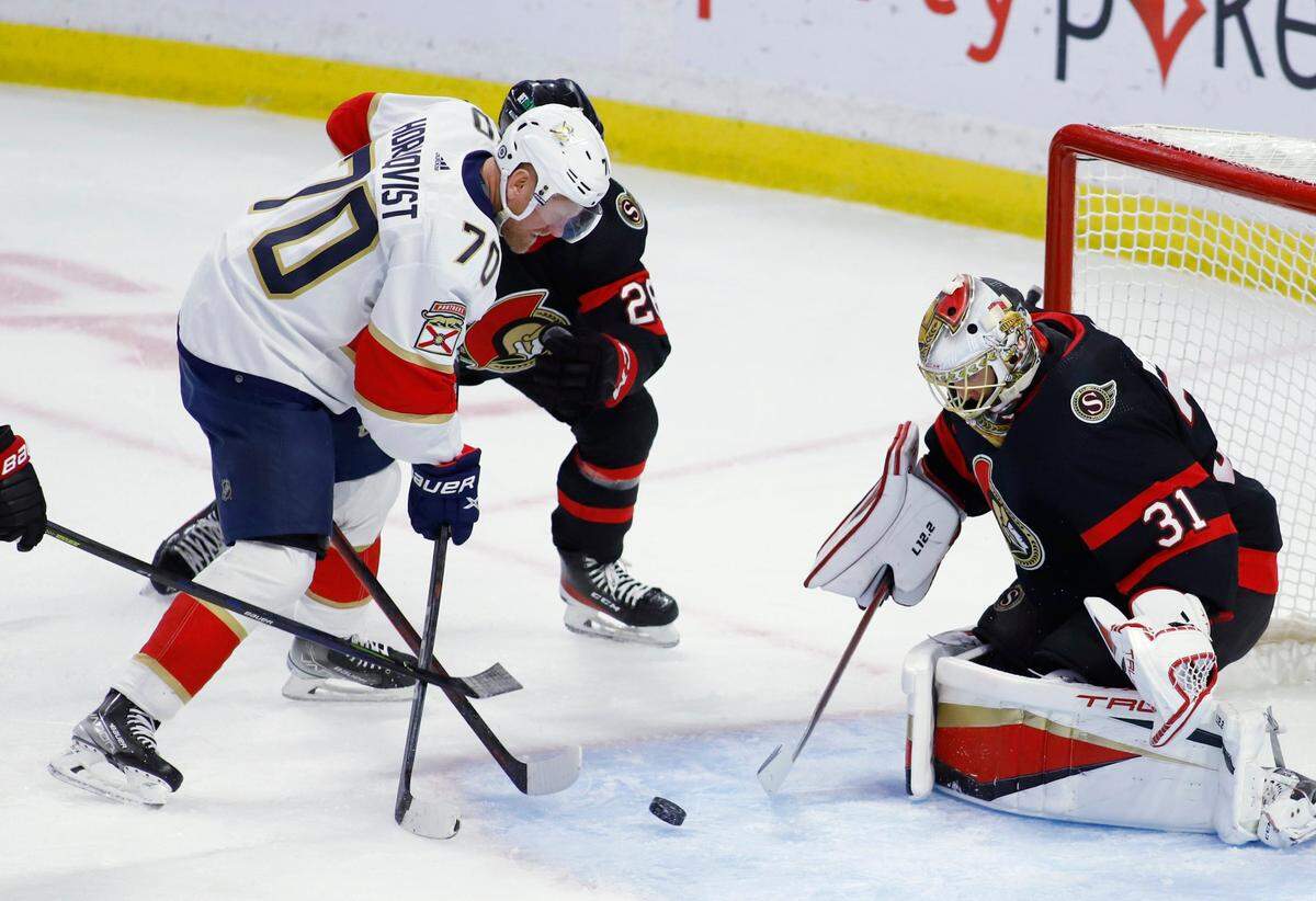 Ottawa Senators goaltender Anton Forsberg (31) makes stops a shot by Florida Panthers’ Patric Hornqvist (70) as Senators’ Erik Brannstrom (26) defends during the first period of an NHL hockey game Saturday, March 26, 2022, in Ottawa, Ontario. (Patrick Doyle/The Canadian Press via AP)