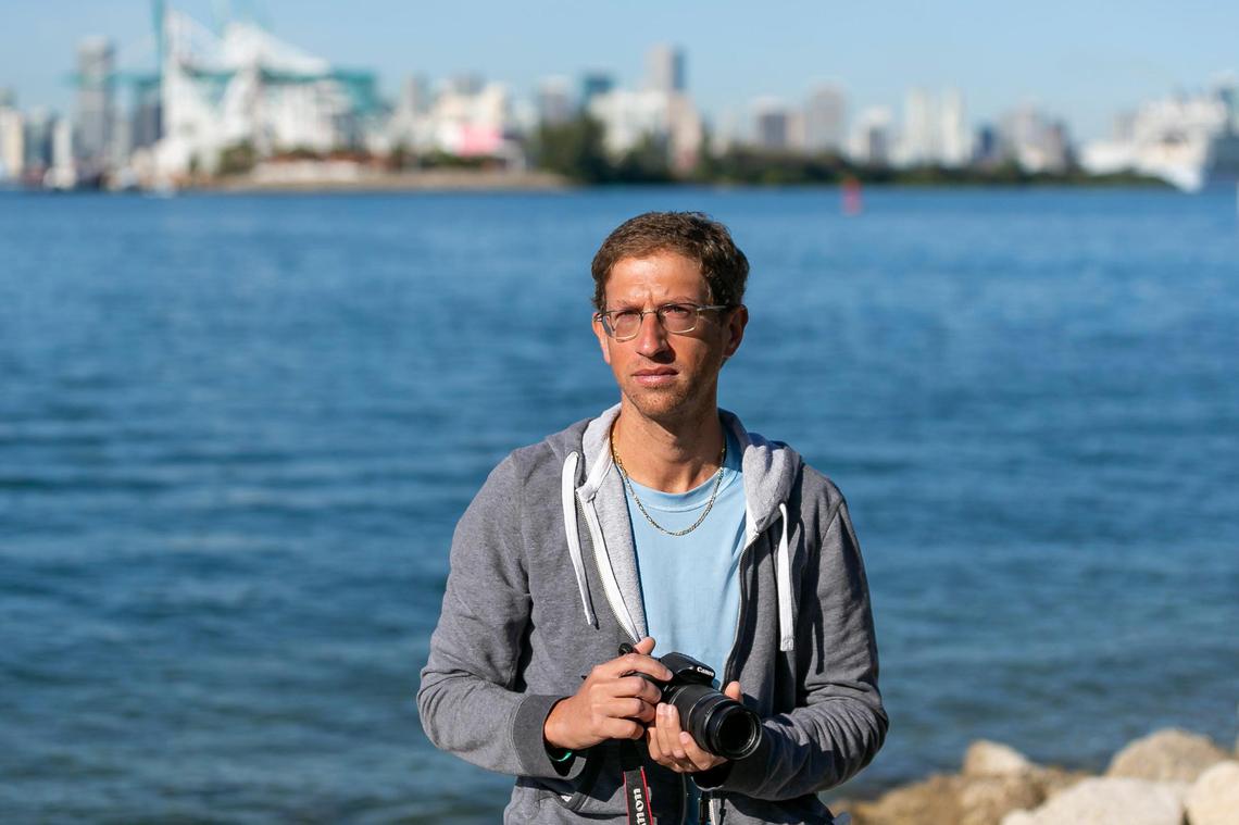 Miami Beach resident Matthew Gultanoff, 35, sits at South Pointe Park on Wednesday, Jan. 20, 2021. Gultanoff often documents cruise ship pollution from the park and worries about its effect on air quality and sea level rise.