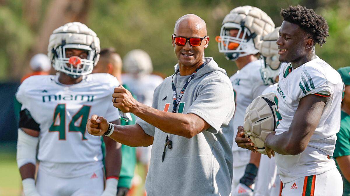 Miami Hurricanes defensive line coach Jason Taylor works with Nyjalik Kelly (9) and Rueben Bain Jr. (44) during practice drills at Greentree Field on the University of Miami campus in Coral Gables on Thursday, March 30, 2023.