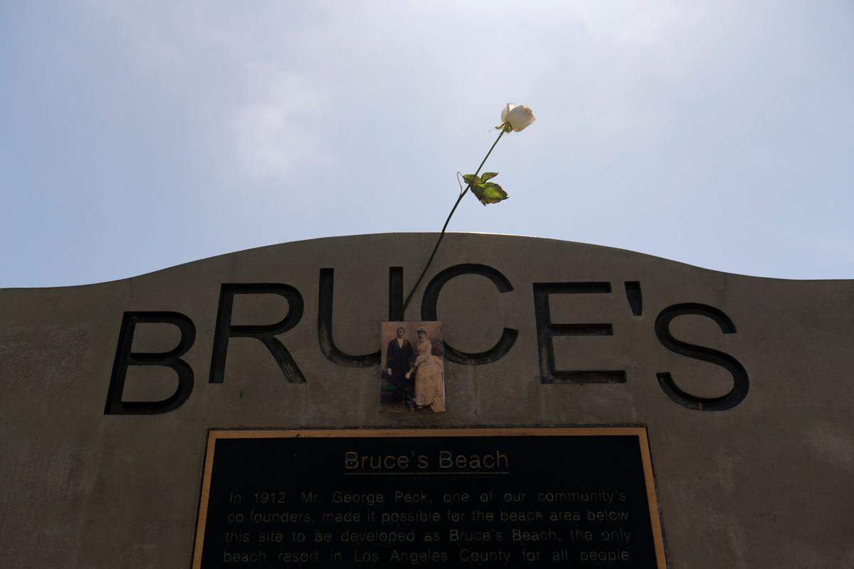 A rose is placed on a monument on Bruce’s Beach in Manhattan Beach, Calif., Wednesday, July 20, 2022. Los Angeles County officials on Wednesday presented the deed to prime California oceanfront property to heirs of a Black couple who built a beach resort for African Americans but were harassed and finally stripped of the land nearly a century ago. The event marked the final step in a complex effort to address the long-ago wrong suffered by Charles and Willa Bruce.