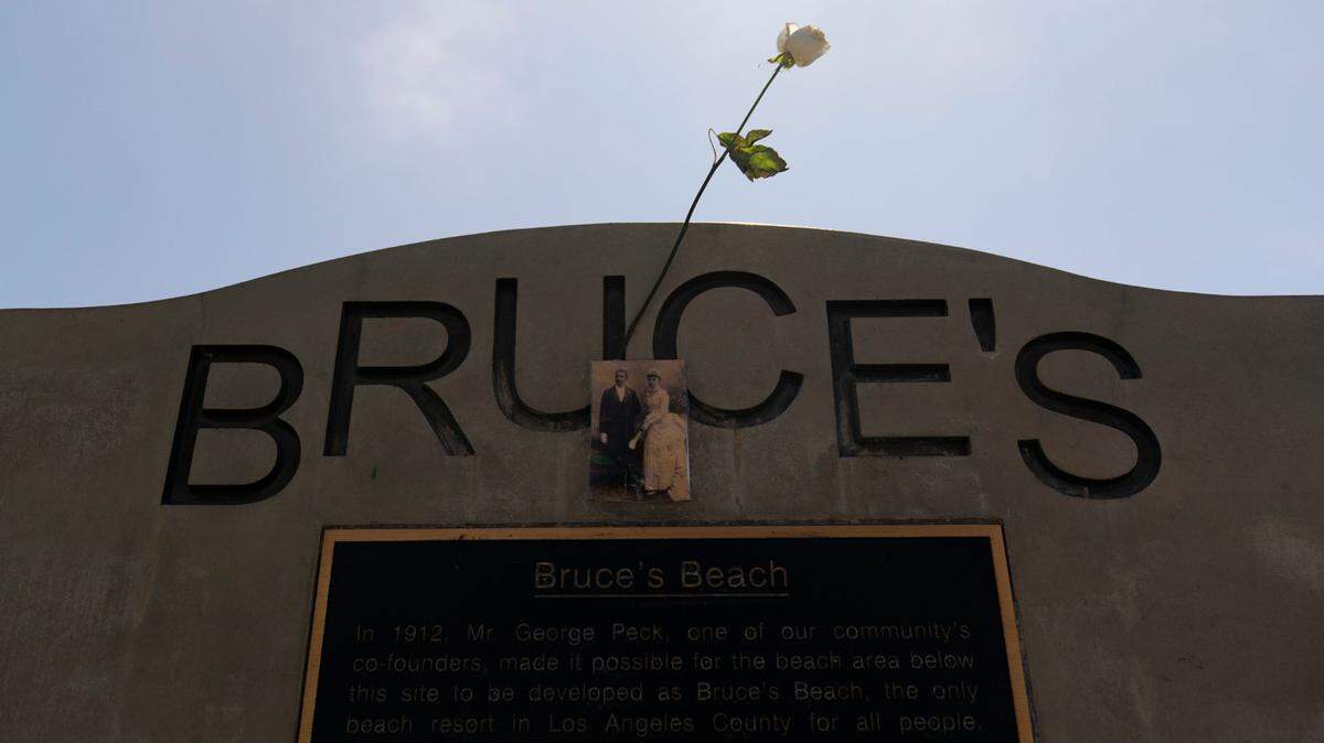 A rose is placed on a monument on Bruce’s Beach in Manhattan Beach, Calif., Wednesday, July 20, 2022. Los Angeles County officials on Wednesday presented the deed to prime California oceanfront property to heirs of a Black couple who built a beach resort for African Americans but were harassed and finally stripped of the land nearly a century ago. The event marked the final step in a complex effort to address the long-ago wrong suffered by Charles and Willa Bruce.