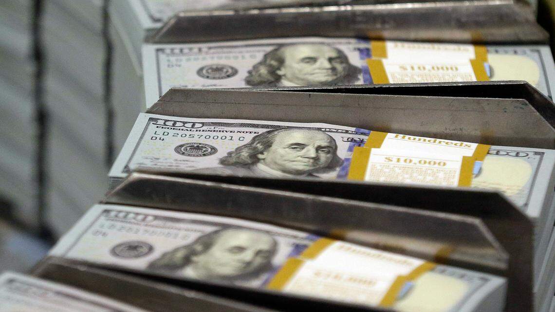 In this Sept. 24, 2013, file photo, freshly cut stacks of $100 bills make their way down the line at the Bureau of Engraving and Printing Western Currency Facility in Fort Worth, Texas. A man who managed a Birmingham, Alabama, grocery store pleaded guilty to food stamp and tax fraud charges.