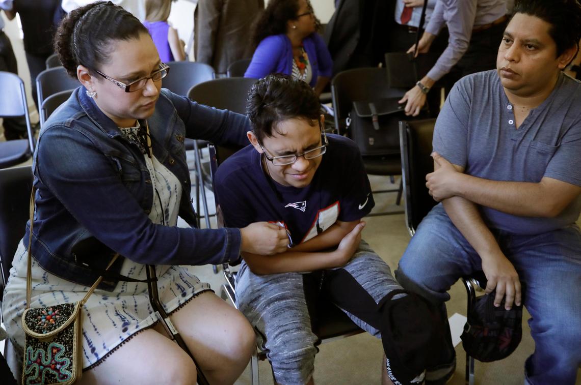 Gary Sanchez, of Honduras, right, watches as his wife, Mariela comforts their son, Jonathan, 16, during a news conference, Monday, Aug. 26, 2019, in Boston. The Sanchez family came to the United States seeking treatment for Jonathan’s cystic fibrosis.