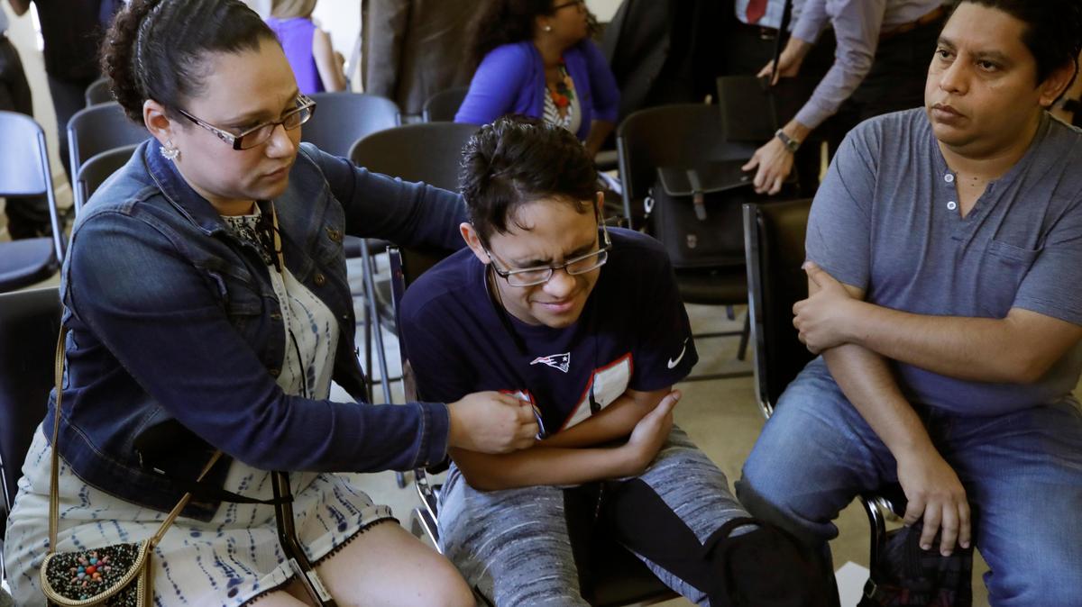 Gary Sanchez, of Honduras, right, watches as his wife, Mariela comforts their son, Jonathan, 16, during a news conference, Monday, Aug. 26, 2019, in Boston. The Sanchez family came to the United States seeking treatment for Jonathan’s cystic fibrosis. Doctors and immigrant advocates said federal immigration authorities were unfairly ordering foreign-born children granted deferred action for medical treatment to return to their countries.
