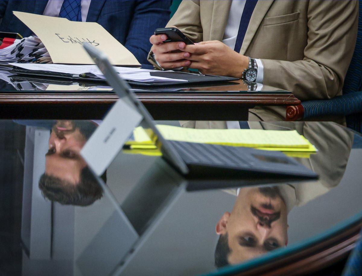 Pictured are the reflections of Emmanuel “Manny” Sarmiento’s attorneys as they wait for the arrival of Judge Peter R. Lopez prior to the hearing being rescheduled on Monday, Aug. 12, 2024, in downtown Miami.