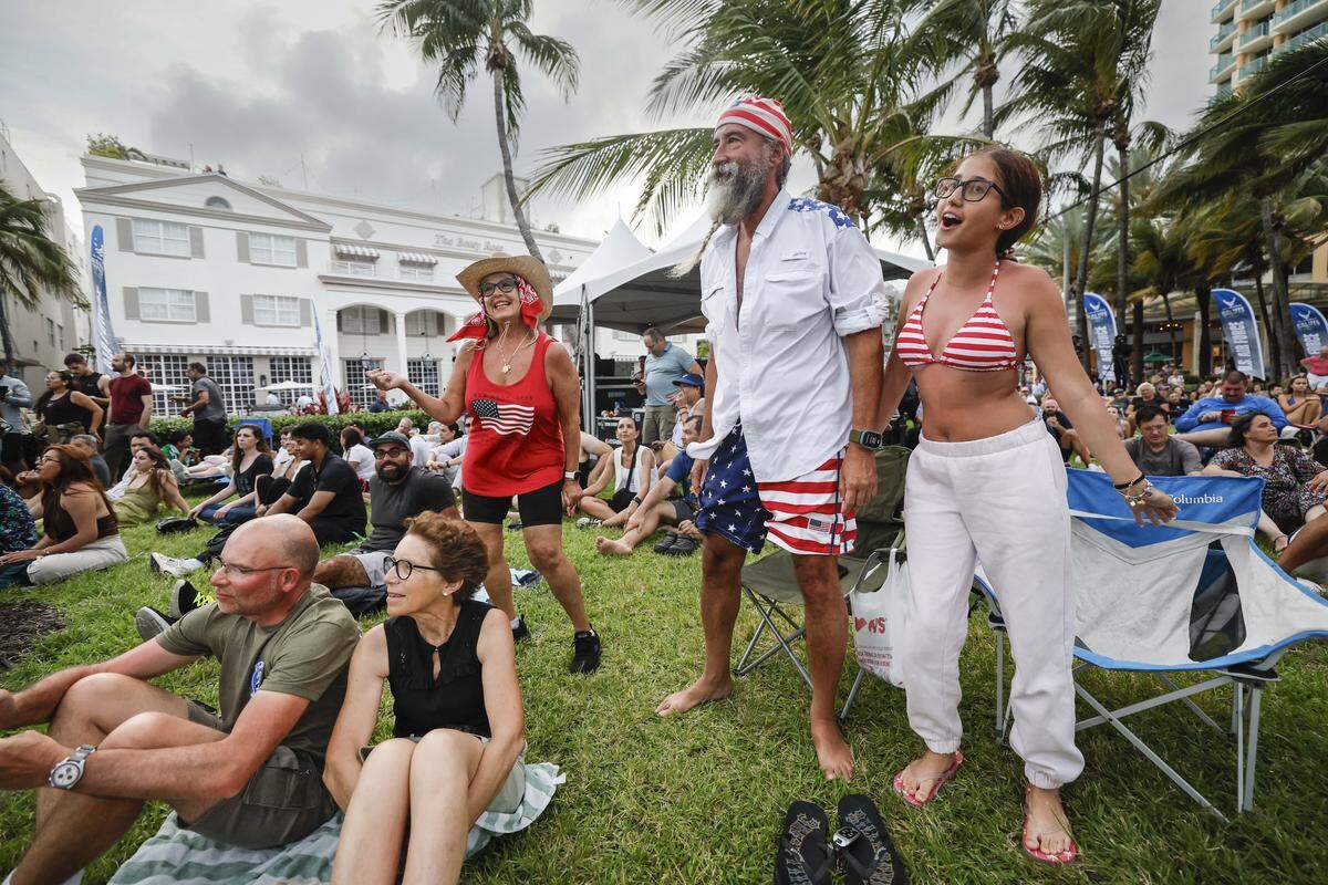 Elena Cairo, Fabio Esendero, and his daughter Izabella Esendero dance to the beat the U.S. Air Force Band performs on stage during Memorial Day Weekend at the Hyundai Air & Sea Show in Miami Beach, Florida, on Saturday, May 23, 2026.