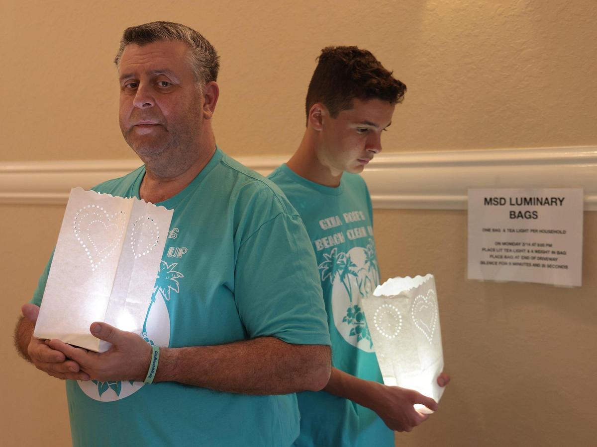 After postponing the annual beach cleanup in honor of his daughter Gina Rose Montalto, Tony Montalto and his son Anthony Montalto III, right, are photographed with luminaries to raise awareness and charitable giving for the foundation that bears his daughter’s name on Sunday, Feb. 13, 2022.