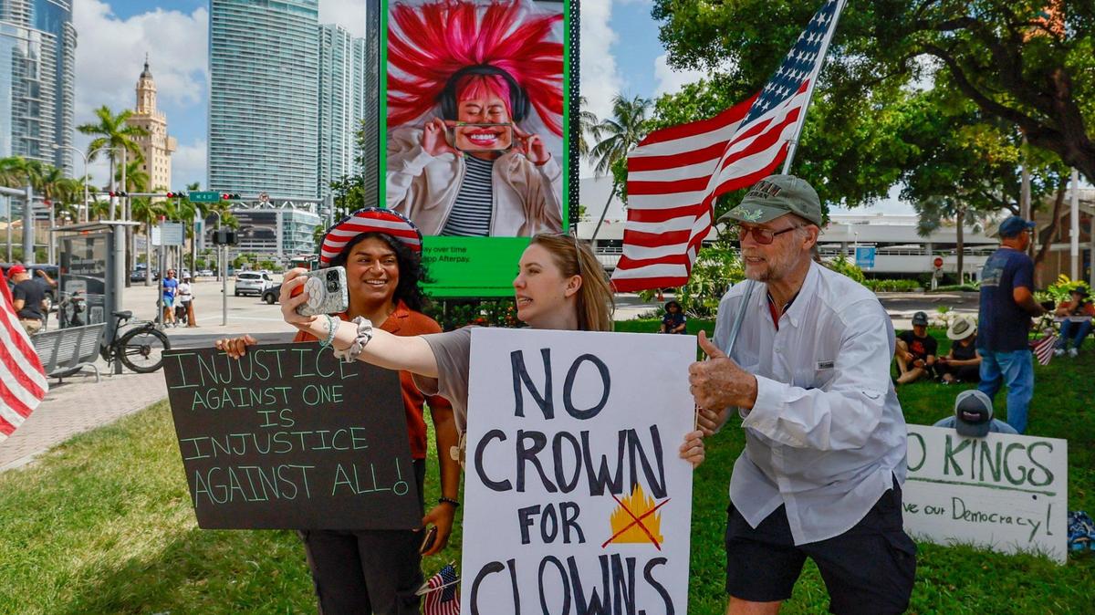 Valarie Bunge, de 34 años, y Bob Remmen, de 74, se toman un selfie durante una protesta anti-Trump “No Kings” en el monumento de la Antorcha de la Amistad en Bayfront Park en Miami, Florida, el sábado 14 de junio de 2025.