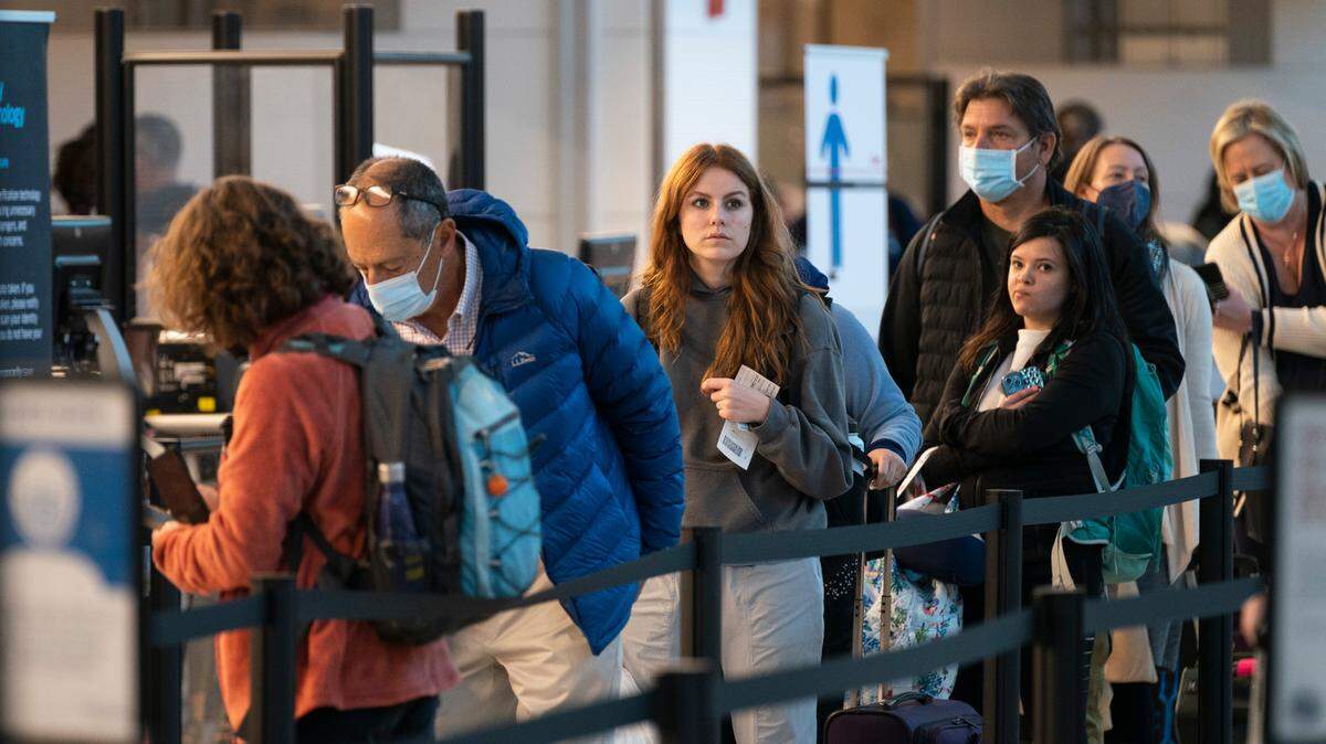 In this stock photo, passengers wait in line at the security checkpoint at Ronald Reagan Washington National Airport, Tuesday, April 19, 2022, in Arlington, Va.
