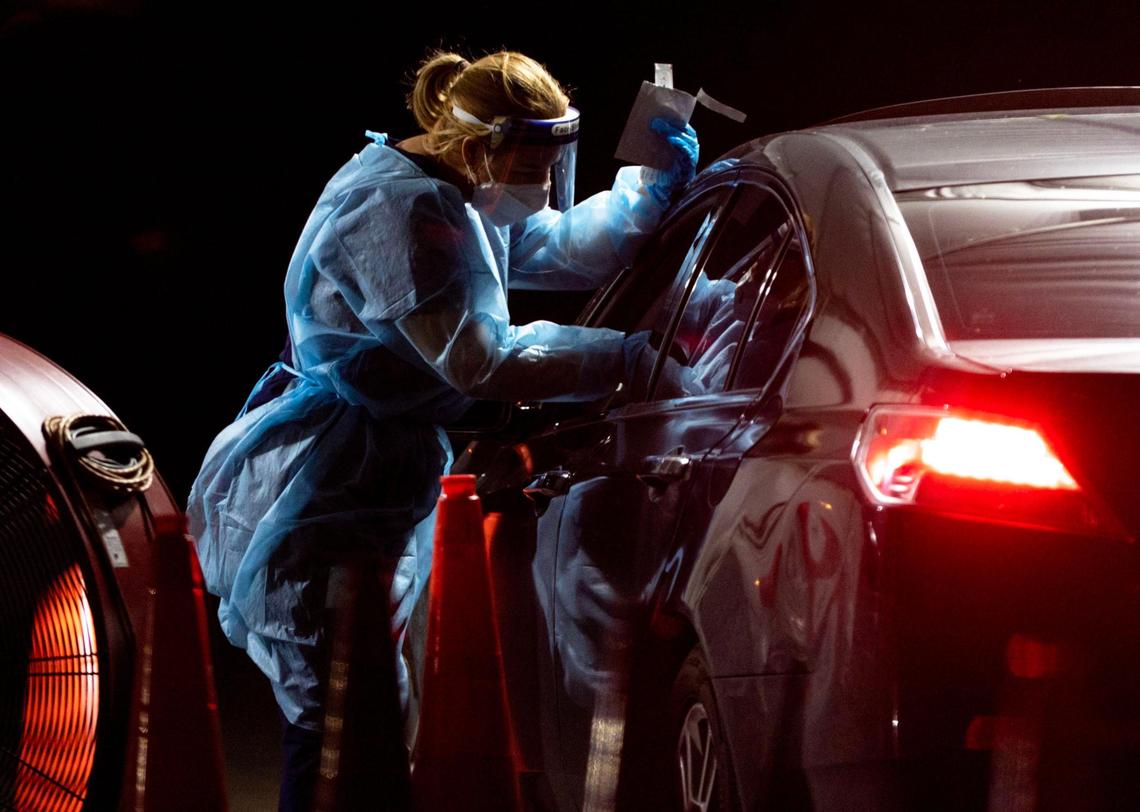 A medical professional administers a nasal swab to a person at the Tropical Park COVID-19 testing site in west Miami-Dade on Thursday.
