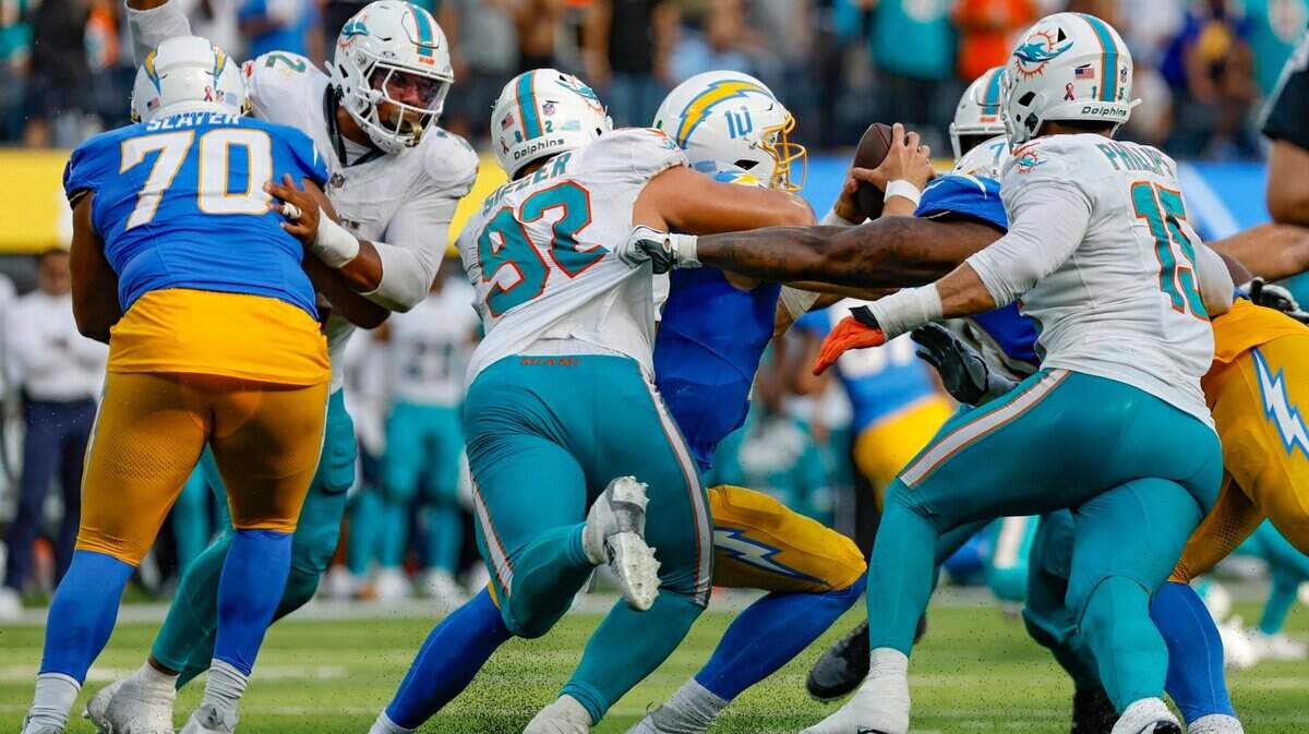 Miami Dolphins defensive tackle Zach Sieler (92) and the Dolphins defense sack Los Angeles Chargers quarterback Justin Herbert (10) late in the fourth quarter at SoFi Stadium in Inglewood, California on Sunday, September 10, 2023.