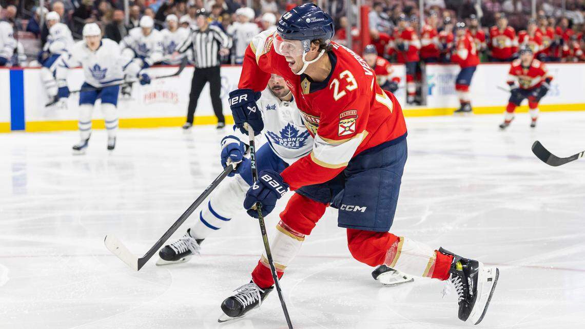 Florida Panthers center Carter Verhaeghe (23) shoots the puck as Toronto Maple Leafs center Auston Matthews (34) defends in the third period of their NHL game at Amerant Bank Arena on Tuesday, April 8, 2025, in Sunrise, Fla.