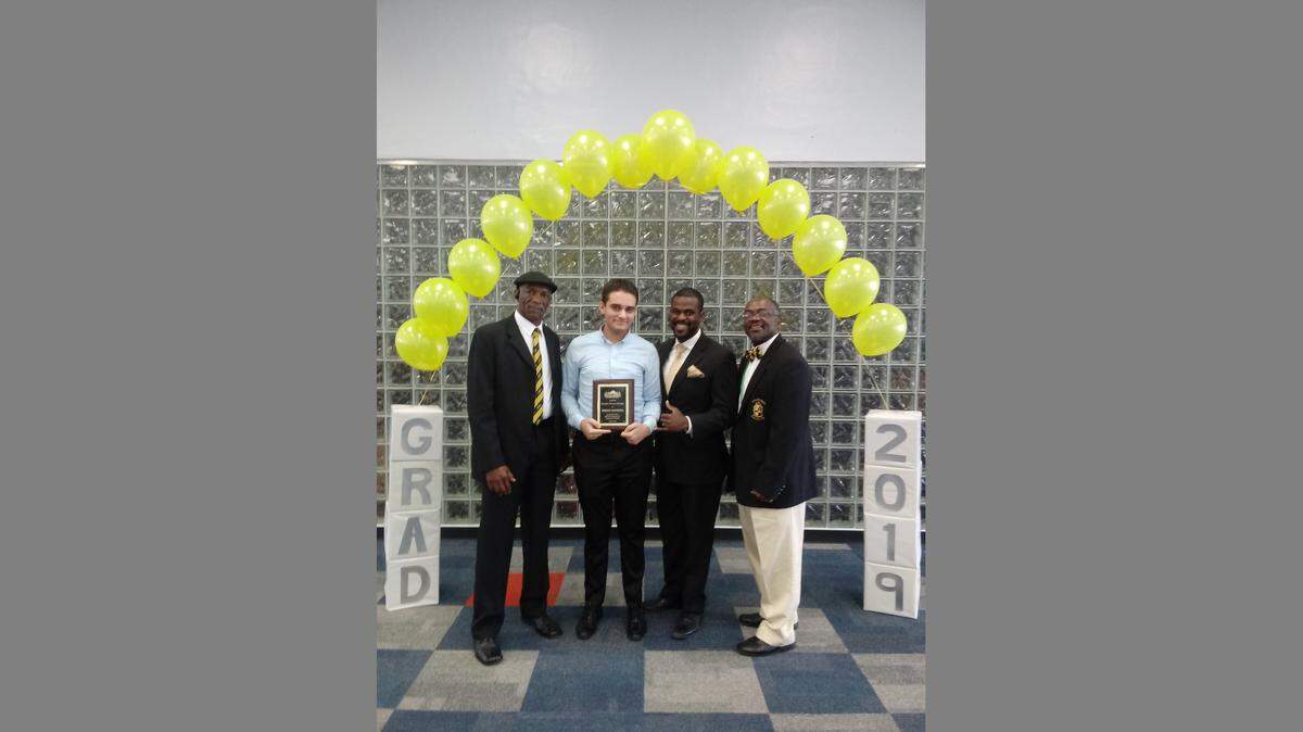 Members of the Iota Pi Lambda Chapter of Alpha Phi Alpha Fraternity awarded Diego Batista, a senior at G. Holmes Braddock Senior High, the Christopher Stevenson Scholarship. Pictured above, from left to right, are Glynell Bradley, Diego Batista, Leslie Elus and Chris Stevenson at Braddock during the award presentation.