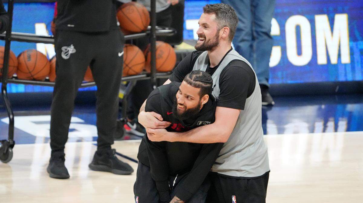 Miami Heat forward Caleb Martin (bottom) and forward Kevin Love (42) play around during a practice session on media day before the 2023 NBA Finals at Ball Arena.