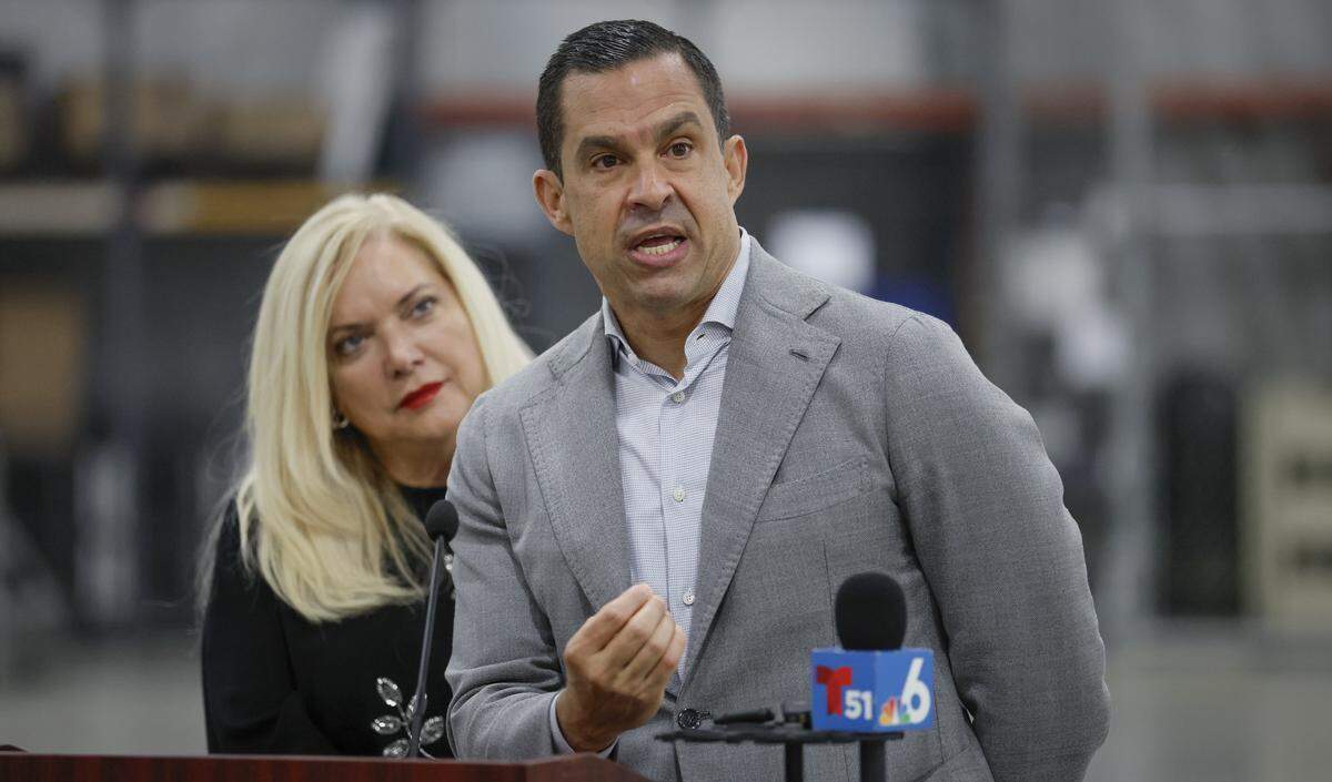 Miami-Dade Supervisor of Elections Alina Garcia listens as Coral Gables Mayor Vince C. Lago speaks to reporters after vote-by-mail ballots were loaded onto a USPS truck at the Miami-Dade Supervisor of Elections Office in Doral, Florida, on Thursday, March 19, 2026. The ballots will be delivered to voters by mail for the upcoming April 21 Coral Gables election.
