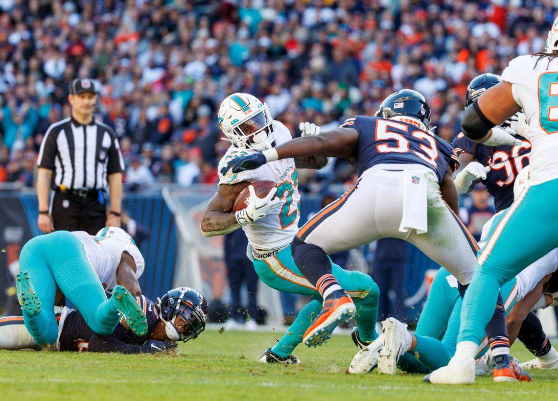 Miami Dolphins running back Jeff Wilson Jr. (23) runs with the football against Chicago Bears linebacker Nicholas Morrow (53) during fourth quarter of an NFL football game at Soldier Field on Sunday, November 6, 2022 in Chicago, Illinois.