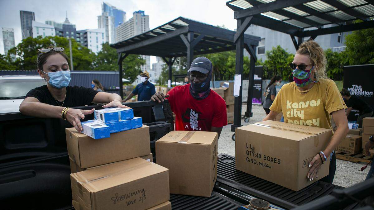 Volunteers load a vehicle with personal protective equipment during a distribution event in Miami’s Overtown neighborhood in July 2020.