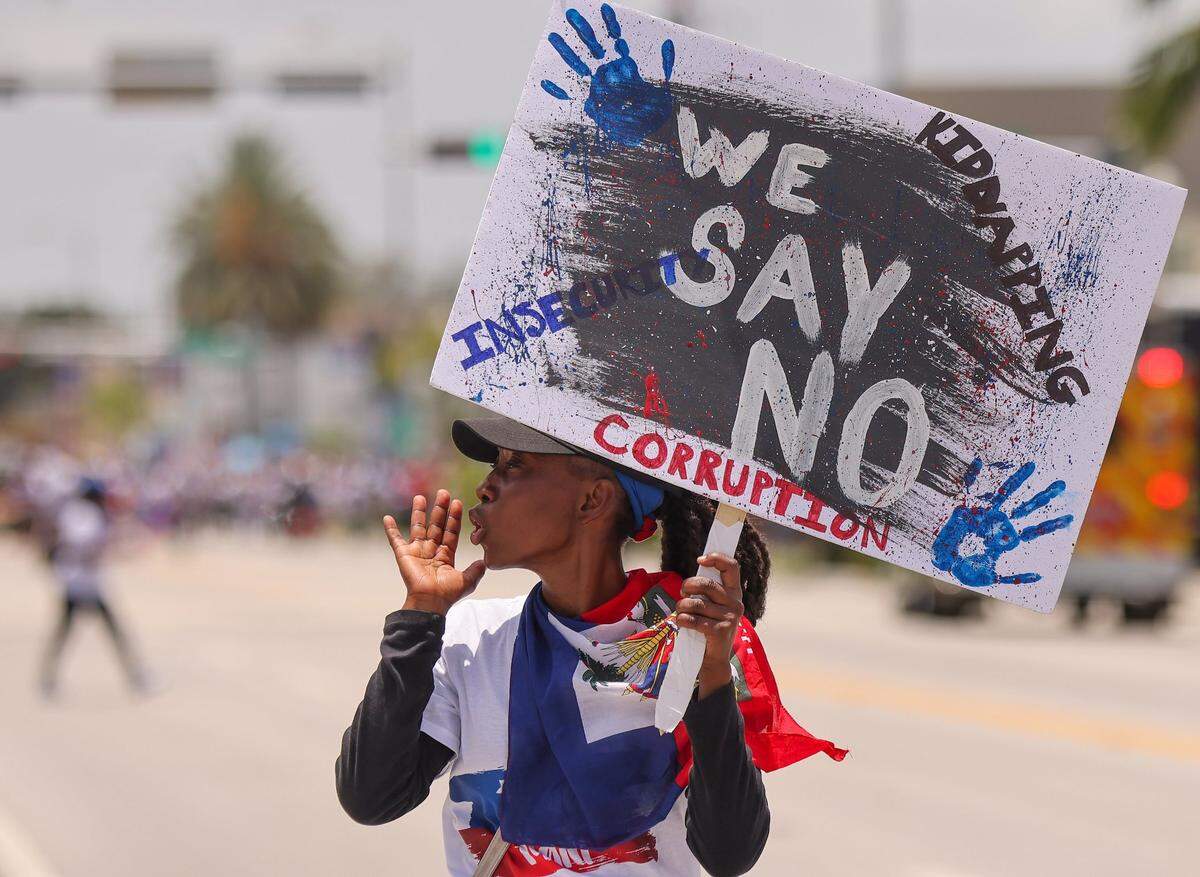 A marcher walks ahead of of the large crowd of about 3,500 North Miami residents, and members of the South Florida Haitian community as they joined Haitians across the United States and the world while marching towards City Hall from North Miami High School on Sunday, July 9, 2023 to demand “Relief for Haiti.”