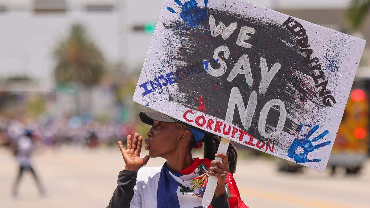 A marcher in July takes part of a rally of about 3,500 South Floridians joining Haitian Americans across the country to demand relief for Haiti.
