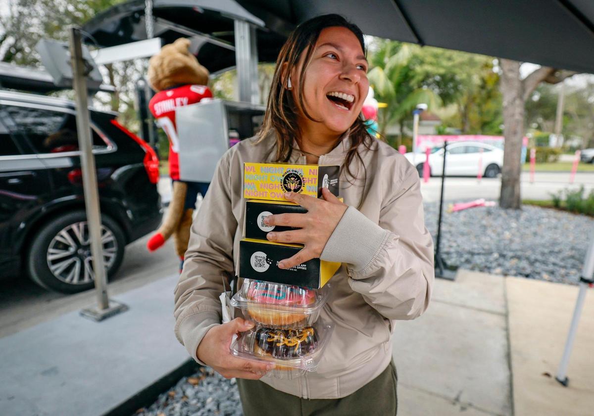 Customer Emily Acevedo carries donuts given to her as El Car Wash celebrates the company’s expansion to over 50 locations in Florida and Michigan. The company also gives back to the community with a $150,000 donation to Baptist Health for pediatric cancer research, marking the third consecutive year of support with over $300,000 raised to date in Miami, Florida on Friday, January 24, 2025.