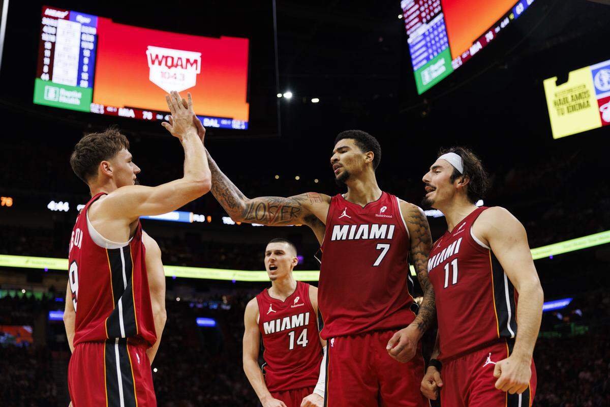 Miami Heat center Kel'el Ware (7) high-fives guard Pelle Larsson (9) with teammates Jaime Jaquez Jr. (11) and Tyler Herro (14) during the second half of a game against the Dallas Mavericks on Monday, Nov. 24, 2025, at the Kaseya Center in downtown Miami, Fla. The Miami Heat won 106-102.