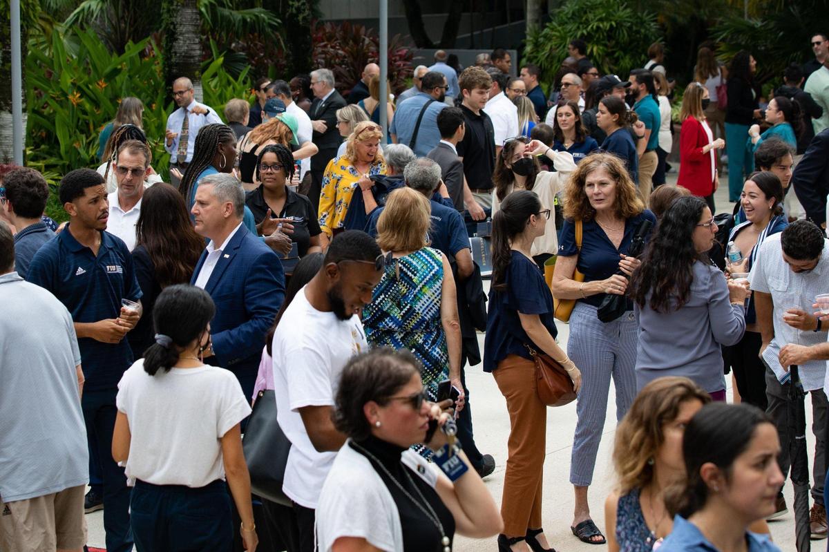 People gather to make a toast to celebrate FIU’s 50th anniversary on the steps of the Charles Perry Building at the Modesto A. Maidique Campus in Miami, Fla., on Monday, Sept. 19, 2022.