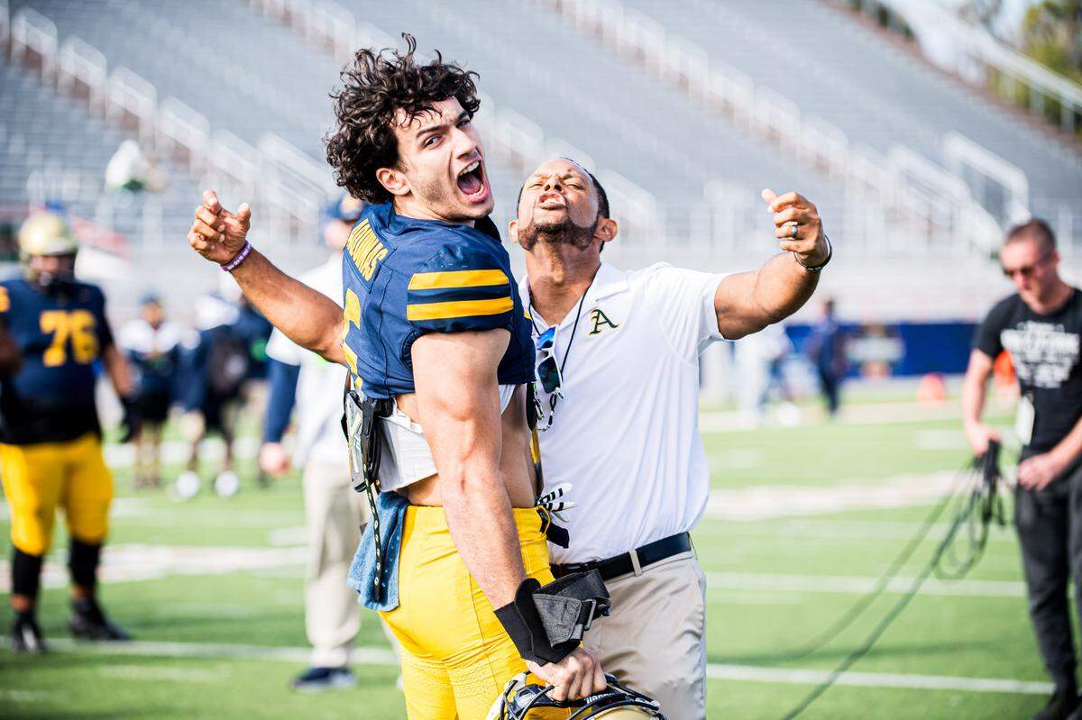 St. Thomas Aquinas linebacker Nicholas Rodriguez and Raiders’ head coach Roger Harriott celebrate during a game this past season. Rodriguez earned Class 4M-3M Defensive Player of the Year honors.