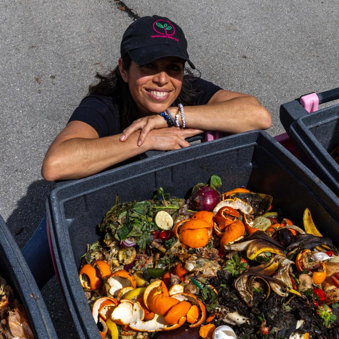 Lanette Sobel smiles with food scraps at the compost drop-off outside of Pinecrest Branch Library.