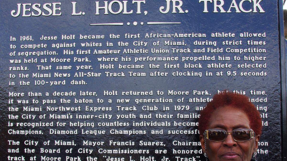 Jesse Holt’s wife, Claudette, stands next to the plaque in honor of her late husband.