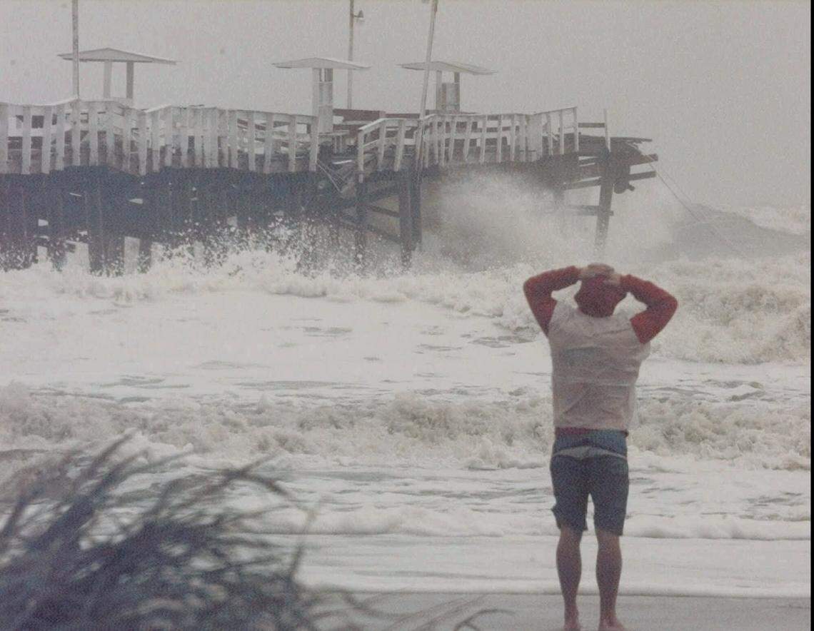 A curious onlooker stands in the surf watching as Hurricane Floyd hammers the Jacksonville Beach Pier on Sept. 15, 1999, in Jacksonville Beach, Florida.