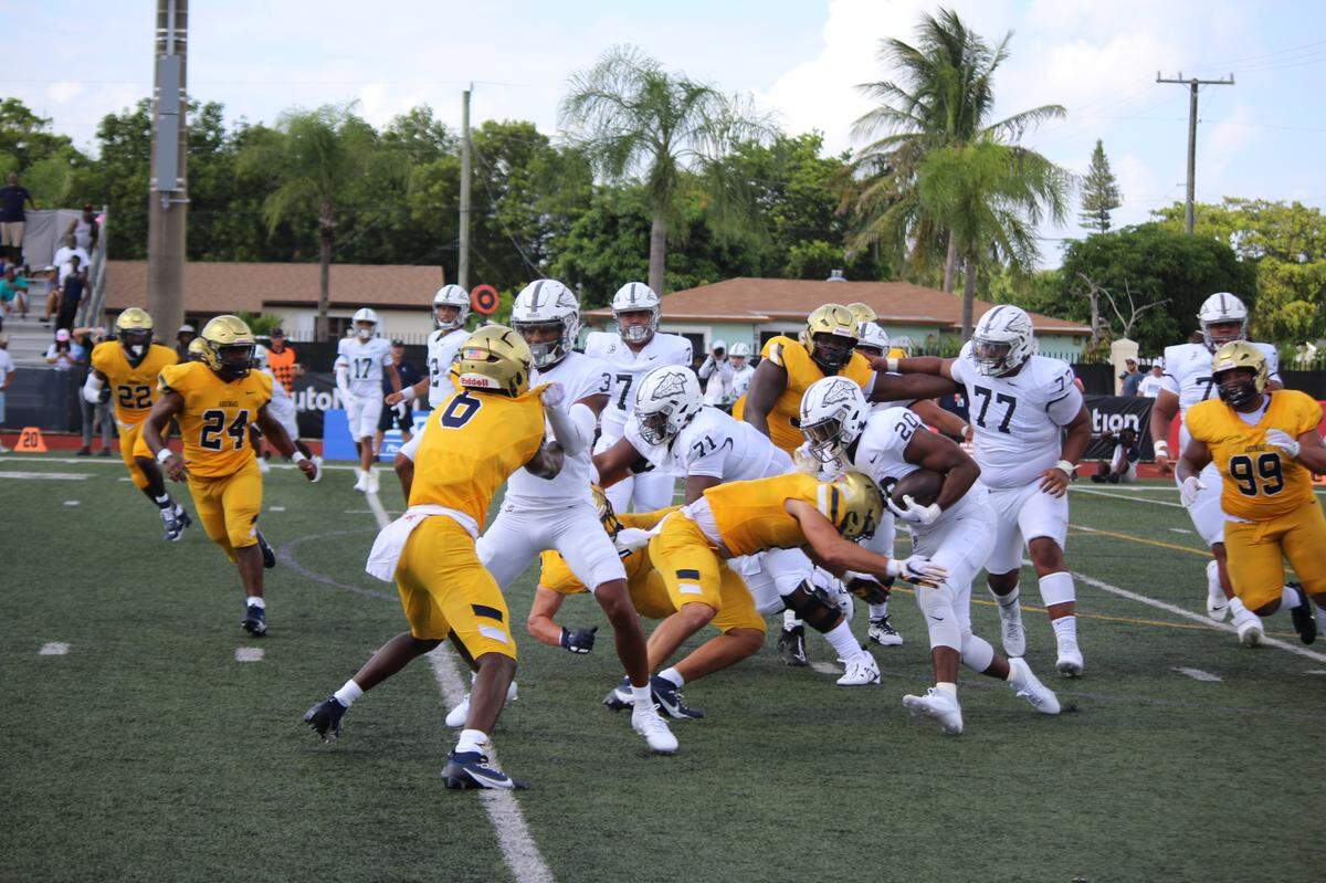 St. Thomas Aquinas linebacker Nicholas Rodriguez delivers a big hit on St. John Bosco running back Cameron Jones during the first half of the Raiders’ game against the Braves on Saturday at Aquinas.