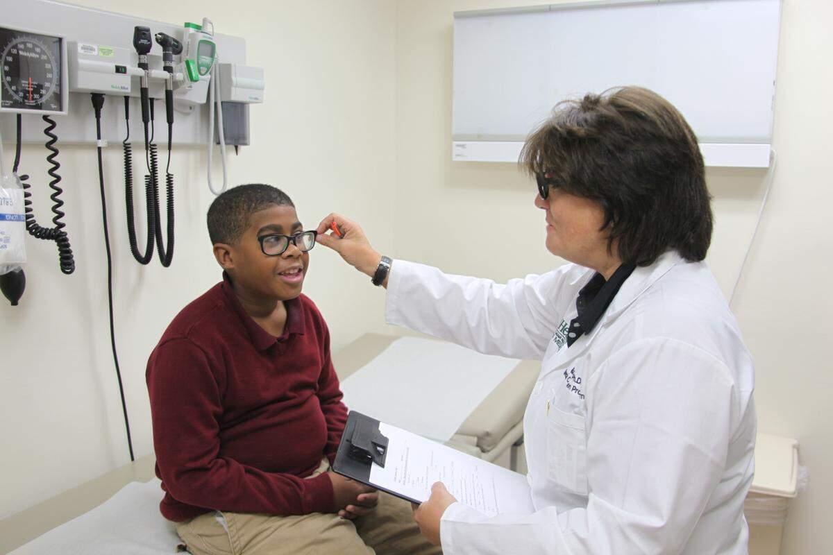 Gillian Hotz, Ph.D., director of UM’s Sports Medicine Institute’s concussion program, examines a patient.