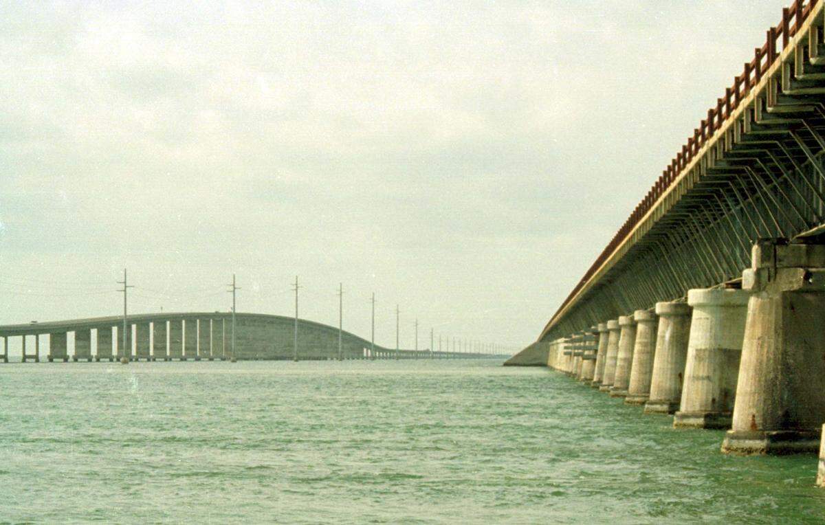 The two Seven Mile Bridges stand as twin sentries of the Florida Keys. This view from Pigeon Key is popular with photographers, especially when the sun sets between the two bridges. The new bridge is on the left.