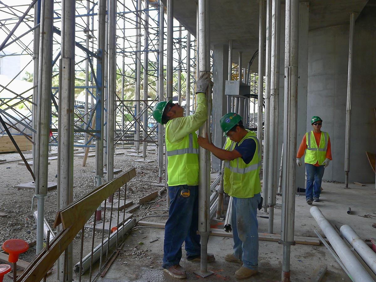 Construction workers secure a metal support beam to shore up the above floor at the Porsche Design Tower, a 60-story super high-end luxury condo, in Sunny Isles Beach in 2014. Thanks to an influx of cheap foreign labor, construction workers in Miami come cheap — at the median, they make less than $14 an hour.