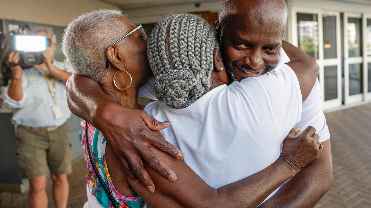Sidney Holmes, de 57 años, es abrazado por su tía Georgia Adams y su madre, Mary Holmes, después de ser liberado de la cárcel, una instalación de máxima seguridad muy cerca de los tribunales de Broward, en el downtown de Fort Lauderdale, el 13 de marzo de 2023. Al Diaz adiaz@miamiherald.com
