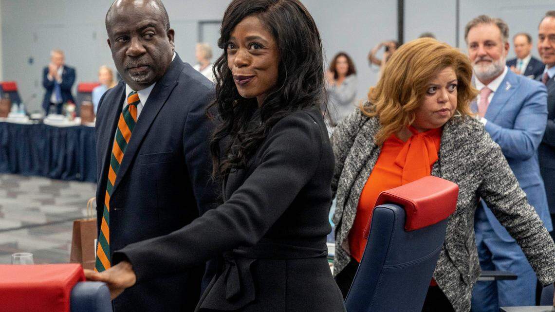 Interim FAMU President Timothy Beard, left, watches Marva Johnson smile after she was confirmed as the new Florida A&M University president, next to FAMU trustee chair Kristin Harper, right, during the Florida Board of Governors meeting at Florida Atlantic University on June 18, 2025 in Boca Raton, Florida.