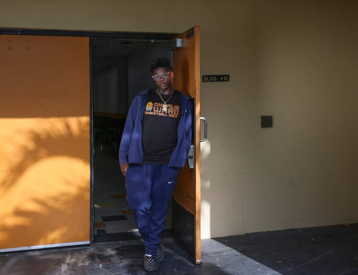Devon Jeremiah Georges, a Haitian American football player at Booker T. Washington High, has been selected as a flag bearer for Miami's third-place World Cup match at Hard Rock Stadium. Georges leans on the school gym door as he reflects on representing Miami-Dade, Thursday, July 16, 2026, in Miami.