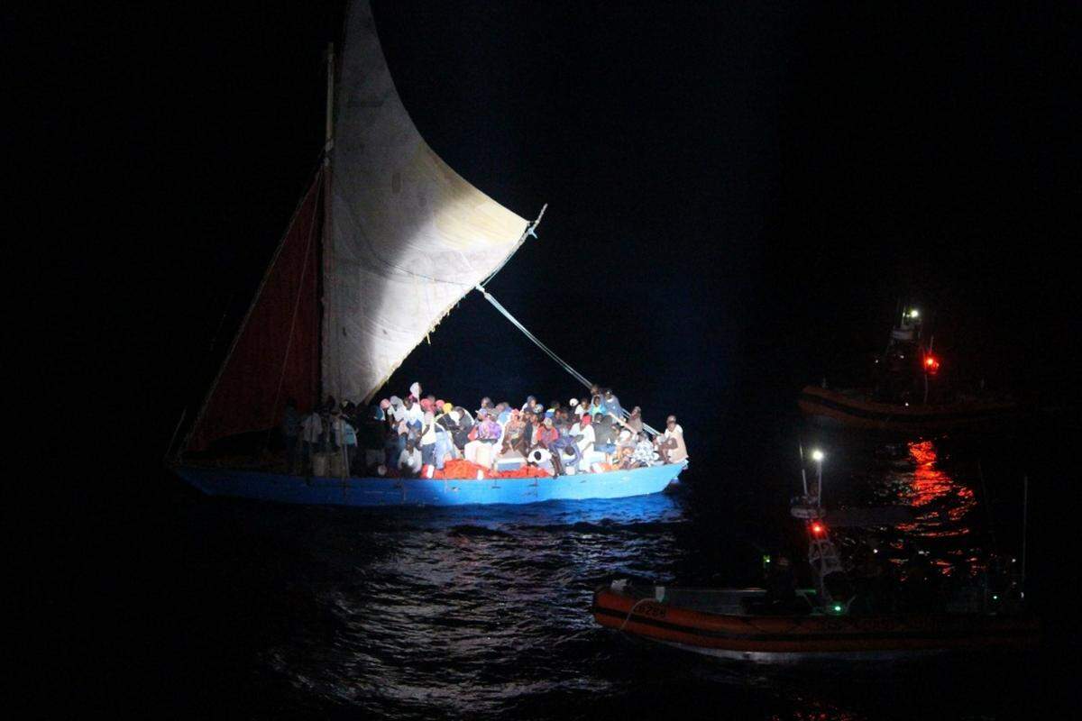Two Coast Guard Cutter Reliance smallboat crews approach an overloaded 70-foot Haitian migrant sail freighter on April 7, 2018, about 30 miles northeast of Moa, Cuba. The cutter crew transferred 50 migrants to the Reliance and repatriated them.