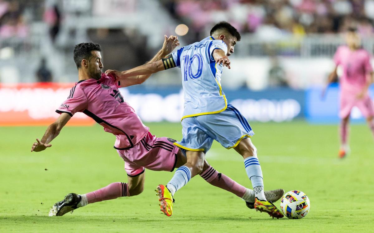 Atlanta United midfielder Thiago Almada (10) runs with the ball as Inter Miami midfielder Sergio Busquets (5) defends in the second half of an MLS match at Chase Stadium on Wednesday, May 29, 2024, in Fort Lauderdale, Fla.