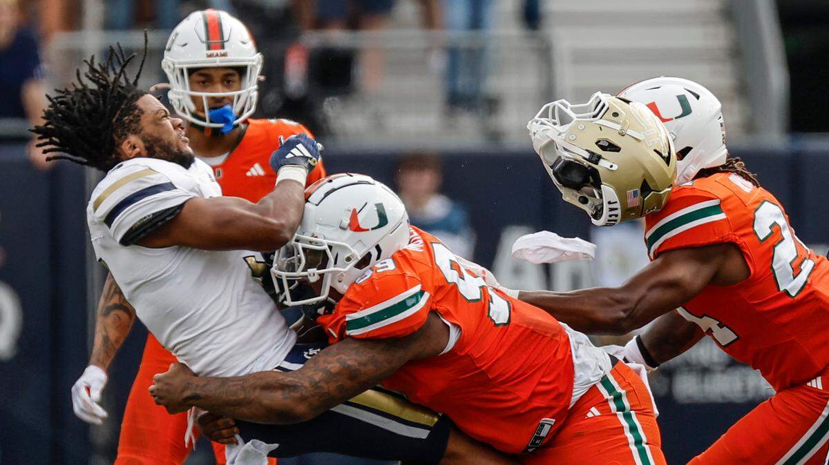 Georgia Tech Yellow Jackets running back Trey Cooley (3) loses his helmet after a hit by Miami Hurricanes defensive lineman Ahmad Moten Sr. (99) in the second half during an NCAA game at Bobby Dodd Stadium at Hyundai Field in Atlanta, Georgia on Saturday, November 9, 2024. 
