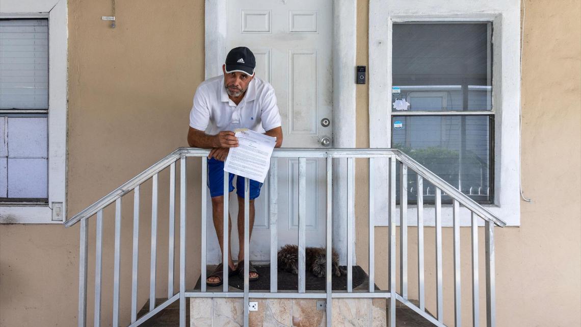 Hamilton Dos Santos stands outside his mobile home, holding the notice to vacate that he received just four months after purchasing his home, on Thursday, Nov. 14, 2024, in Sweetwater, Florida.