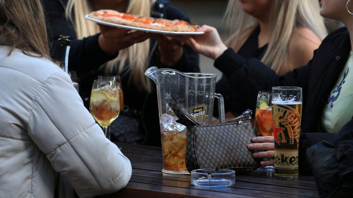 A group of friends eat pizza at a table outside the Water Lane Boathouse bar in Leeds, northern England on April 12, 2021, as coronavirus restrictions are eased across the country in step two of the government’s roadmap out of England’s third national lockdown.