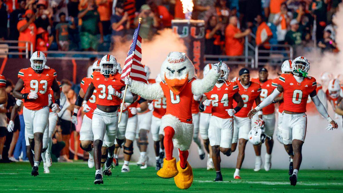 The Miami Hurricanes charge the field for the start of the game against the Virginia Tech Hokies in an ACC conference football game at Hard Rock Stadium on Friday, September 27, 2024, in Miami Gardens, Fla.