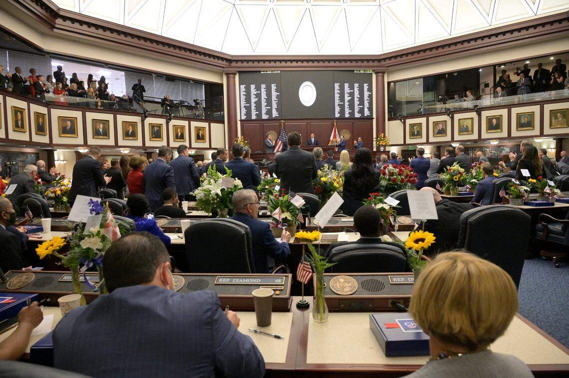 Democratic members remain sitting as Republicans stand and applaud while Florida Gov. Ron DeSantis addresses a joint session of the Legislature, Tuesday, Jan. 11, 2022, in Tallahassee, Fla.