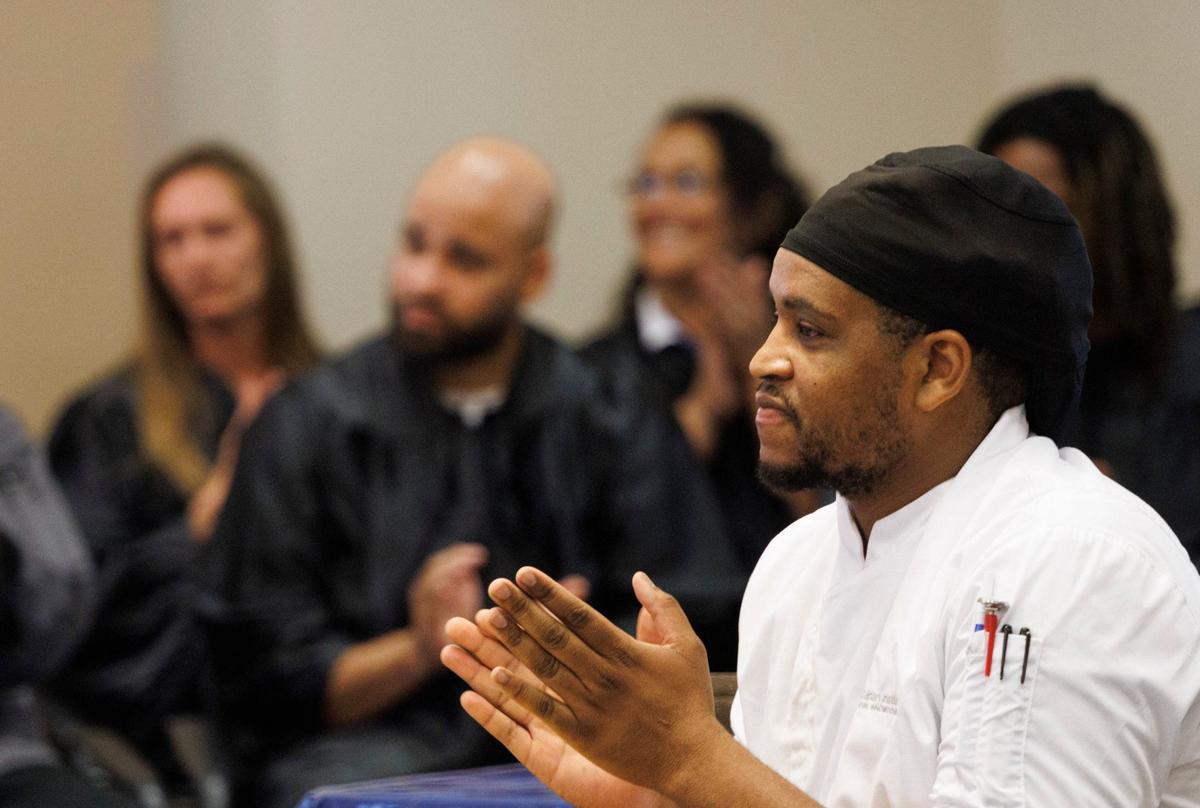 Kendrick Moore, an assistant culinary instructor who previously completed the program himself, claps for his students during a graduation ceremony for the Kitchen Cook program on Wednesday, Sept. 11, 2024, at Camillus House in Miami. Moore said he was a Marine Corps veteran who became homeless after getting medically discharged. After a few years of living in his car, he found Camillus House and the programs it offered. He now works there to give back.